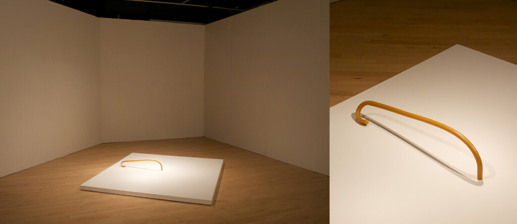 Side-by-side images of two different views of a sculpture on a low plinth.