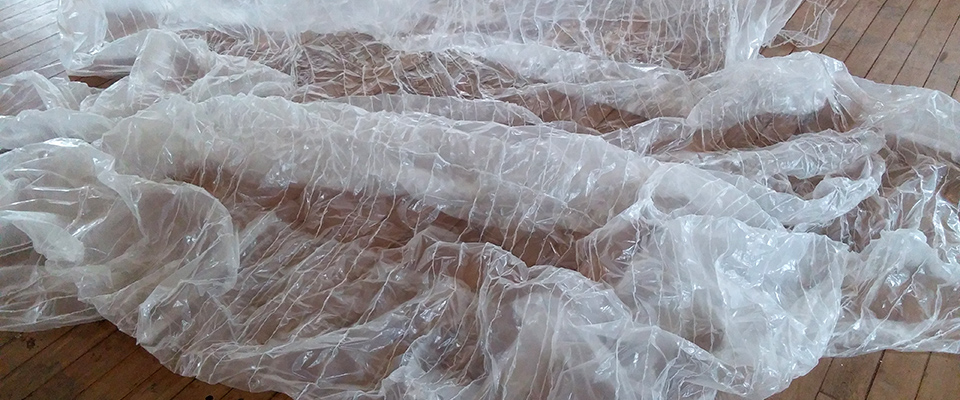 A shiny white material strewn across a wooden floor.