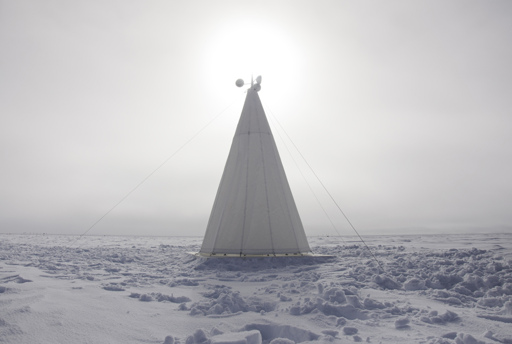 A conical tent structure erected in a snowy landscape.