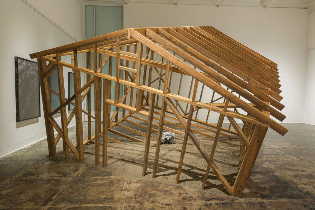 A canted wooden structure within a gallery.
