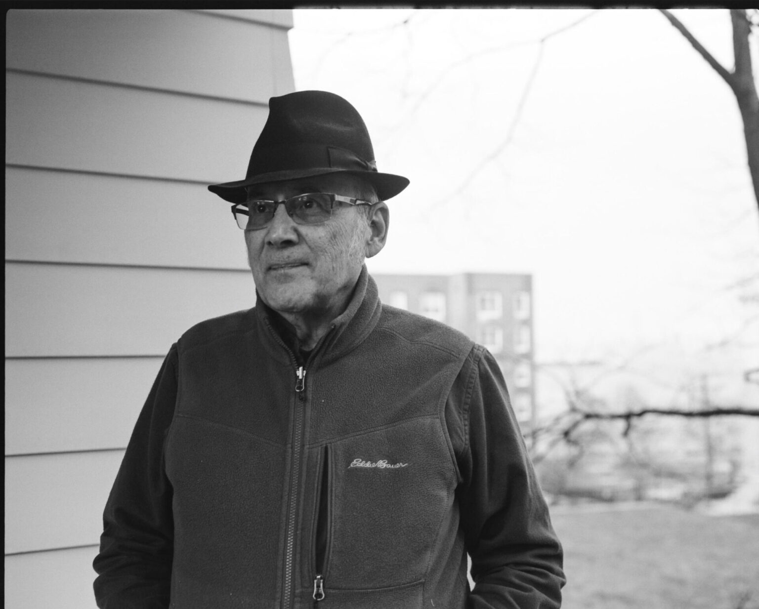 Black and white portrait of Guy in a fedora hat and glasses.