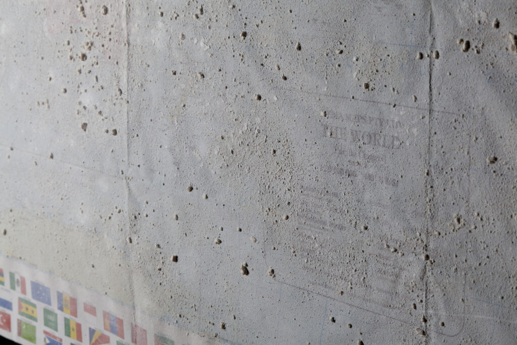 A concrete wall with text and flags on it.