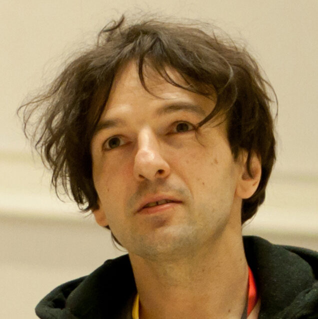 A portrait of a person against a light background.