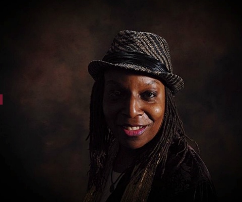 A portrait of a person against a dark background.