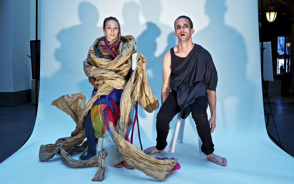 Two people sitting in front of a seamless backdrop roll.
