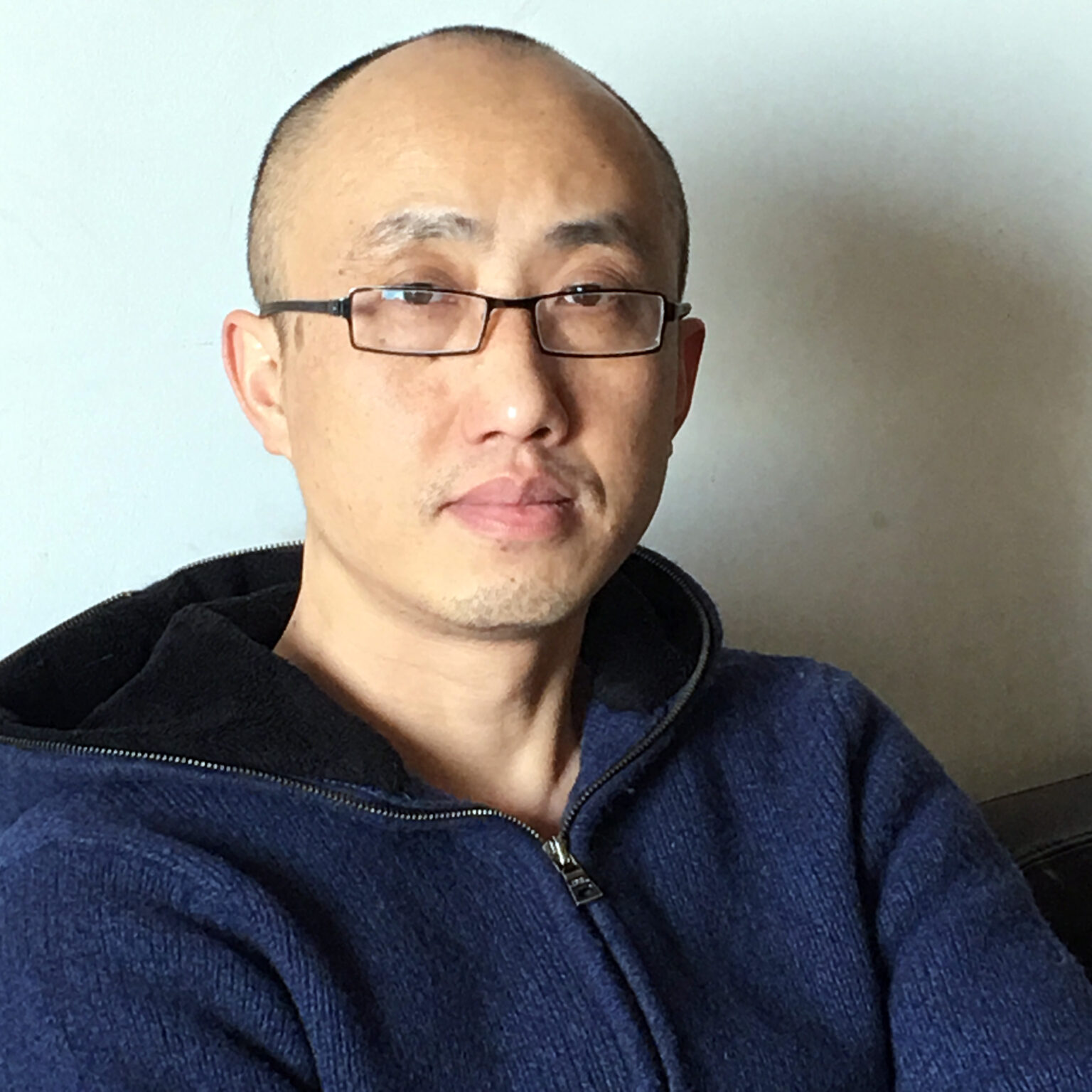 A portrait of a person against a light background.