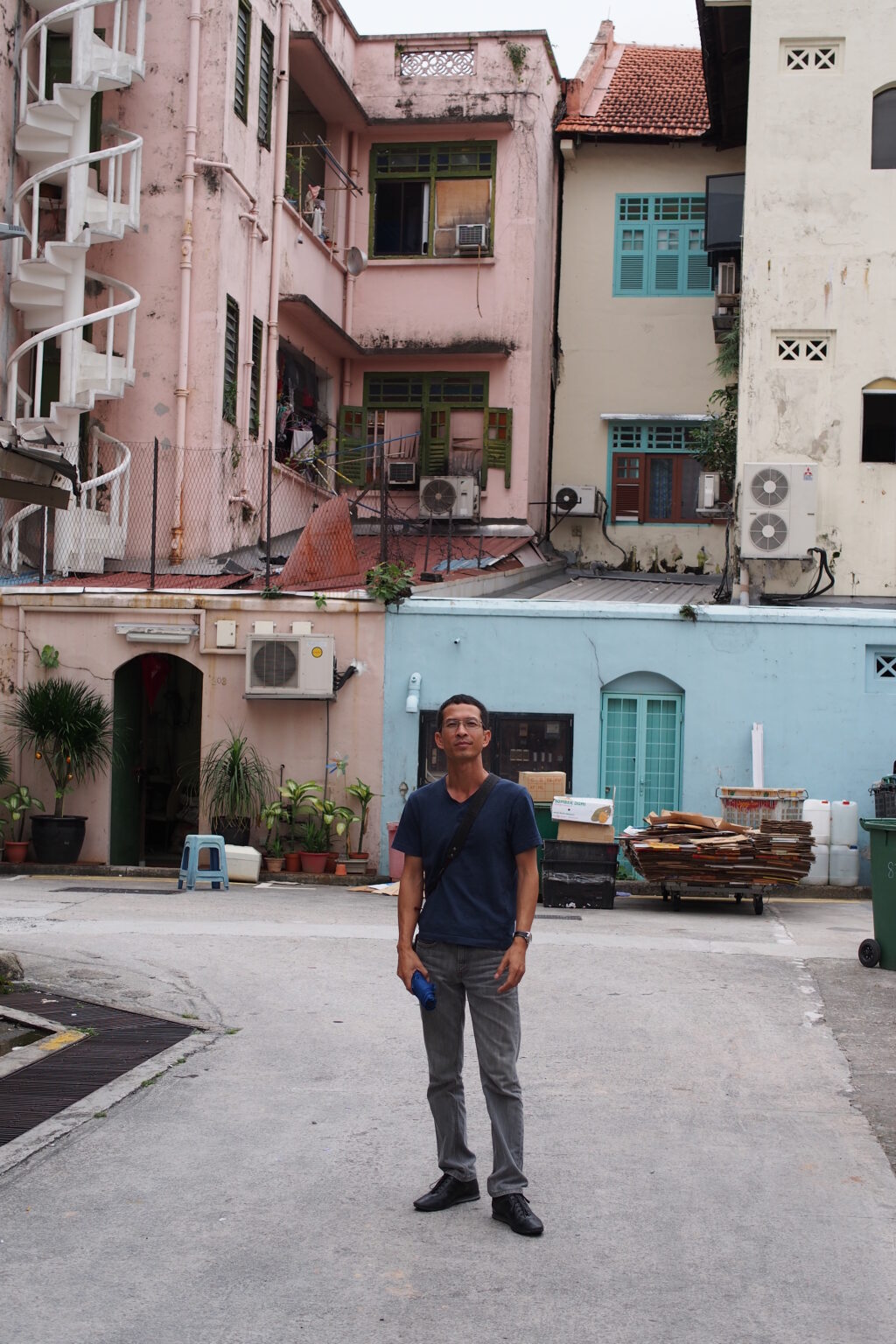 A person standing in front of pastel-colored buildings.