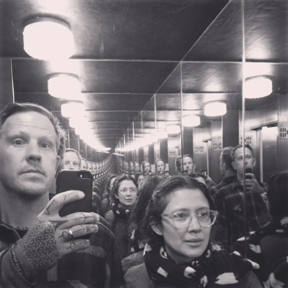 Two people in a mirrored room reflecting their image.