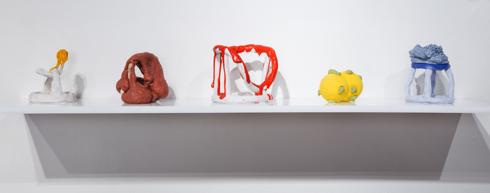 A shelf with five differently-shaped sculptures.