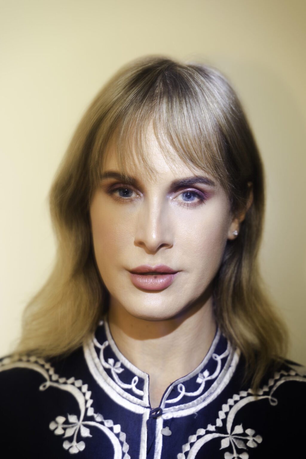 Zackary wearing a black top with ornate white detailing.