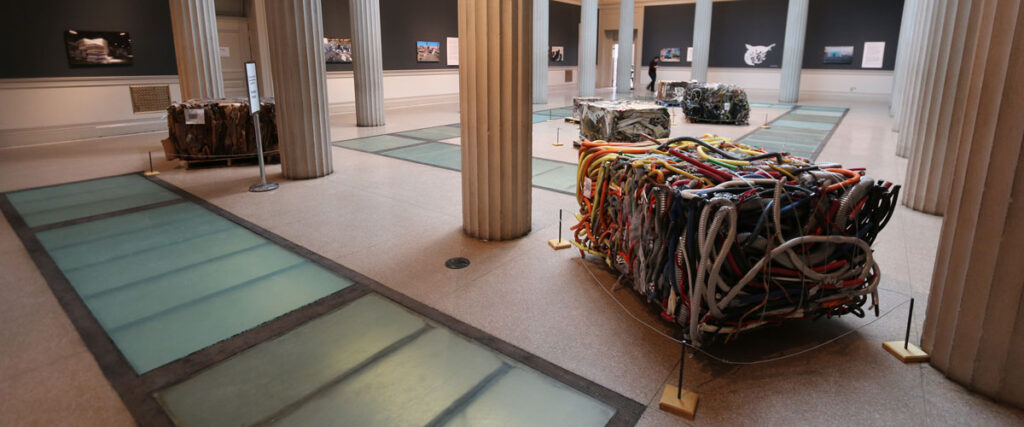 The interior of a gallery with artworks installed on the walls and the the showroom floor.