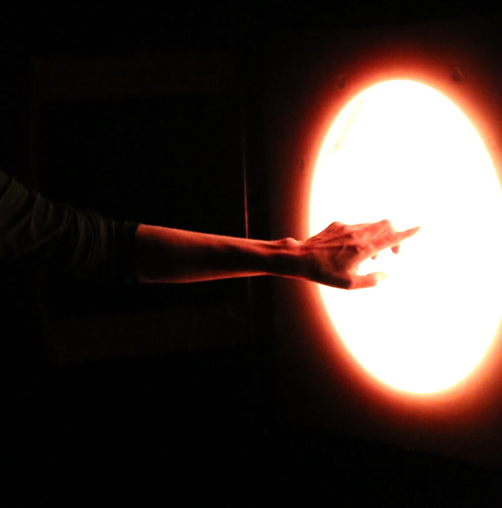 A person reaching their hand toward a circle of light.