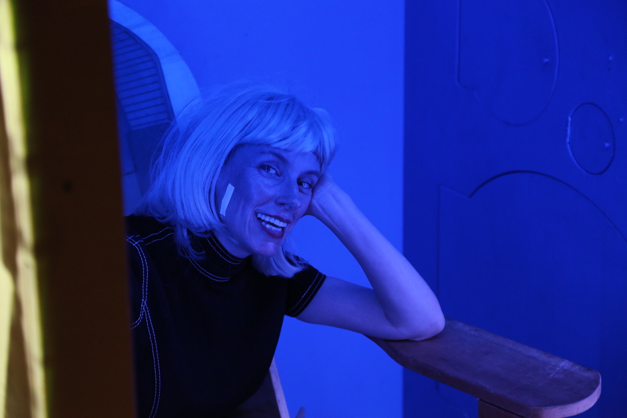 A portrait of a person lit by an indigo light.