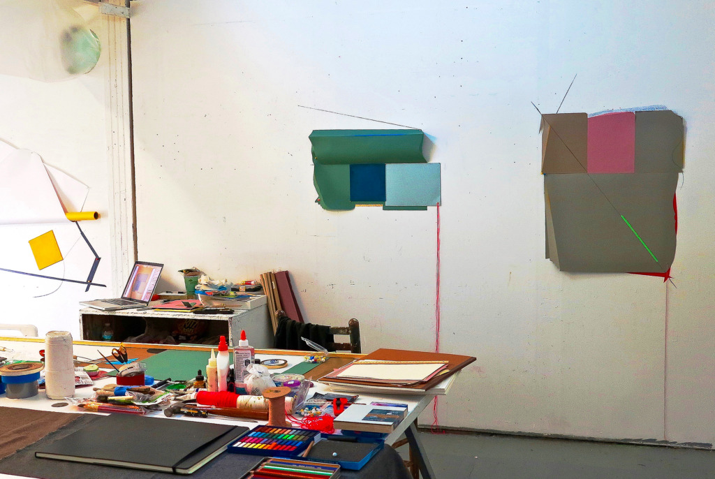 A studio with colorful collaged works on the wall