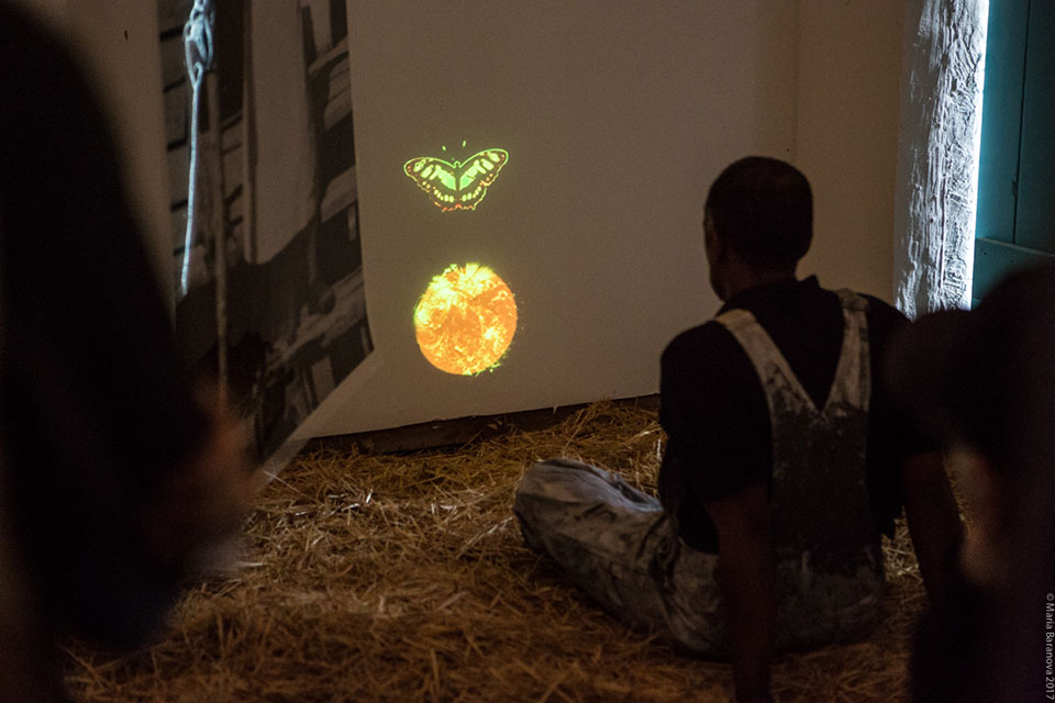 People sitting and looking at projected images on a wall.