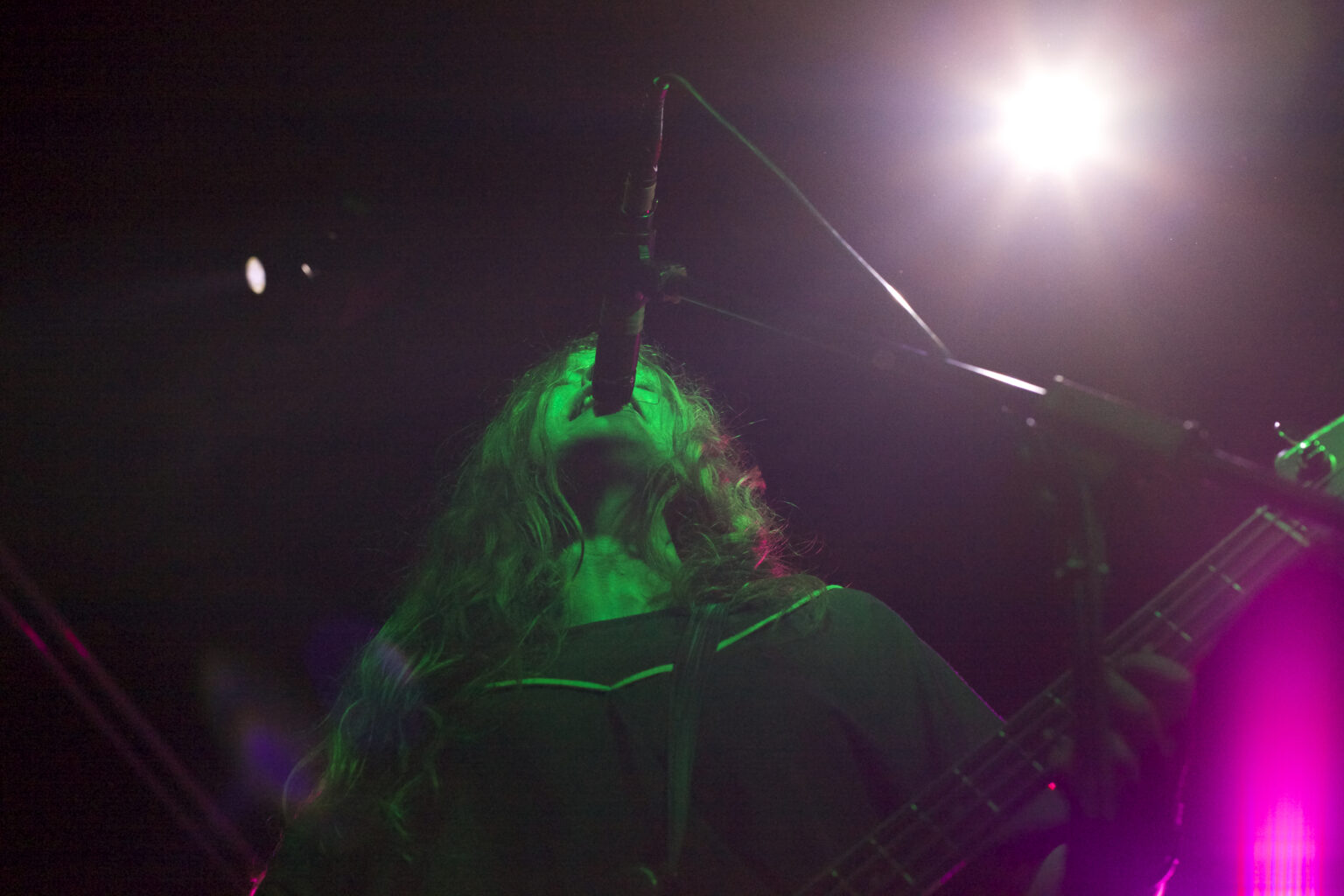 A low-angle shot of a person singing into a microphone.