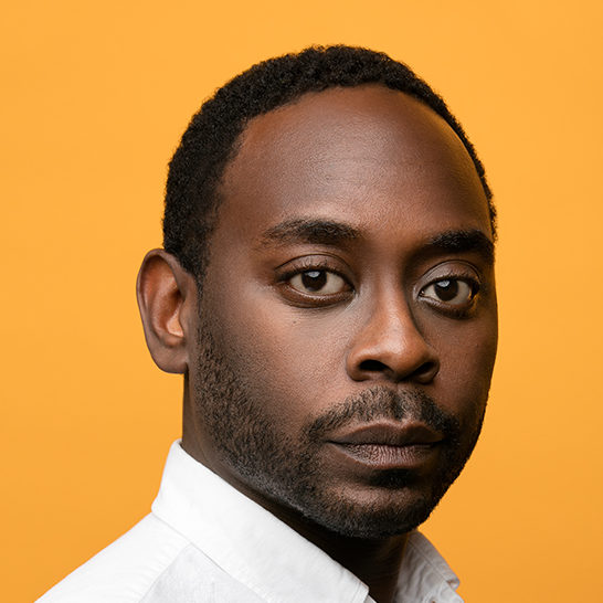 A portrait of a person against a yellow background.