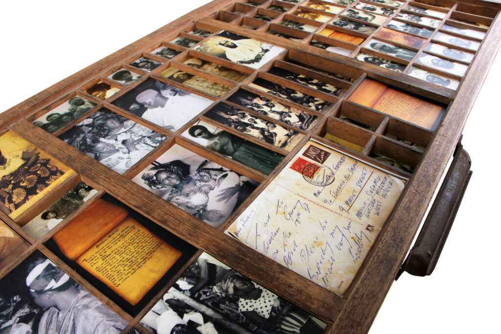 A box with photographs, letters, and postcards displayed in it.