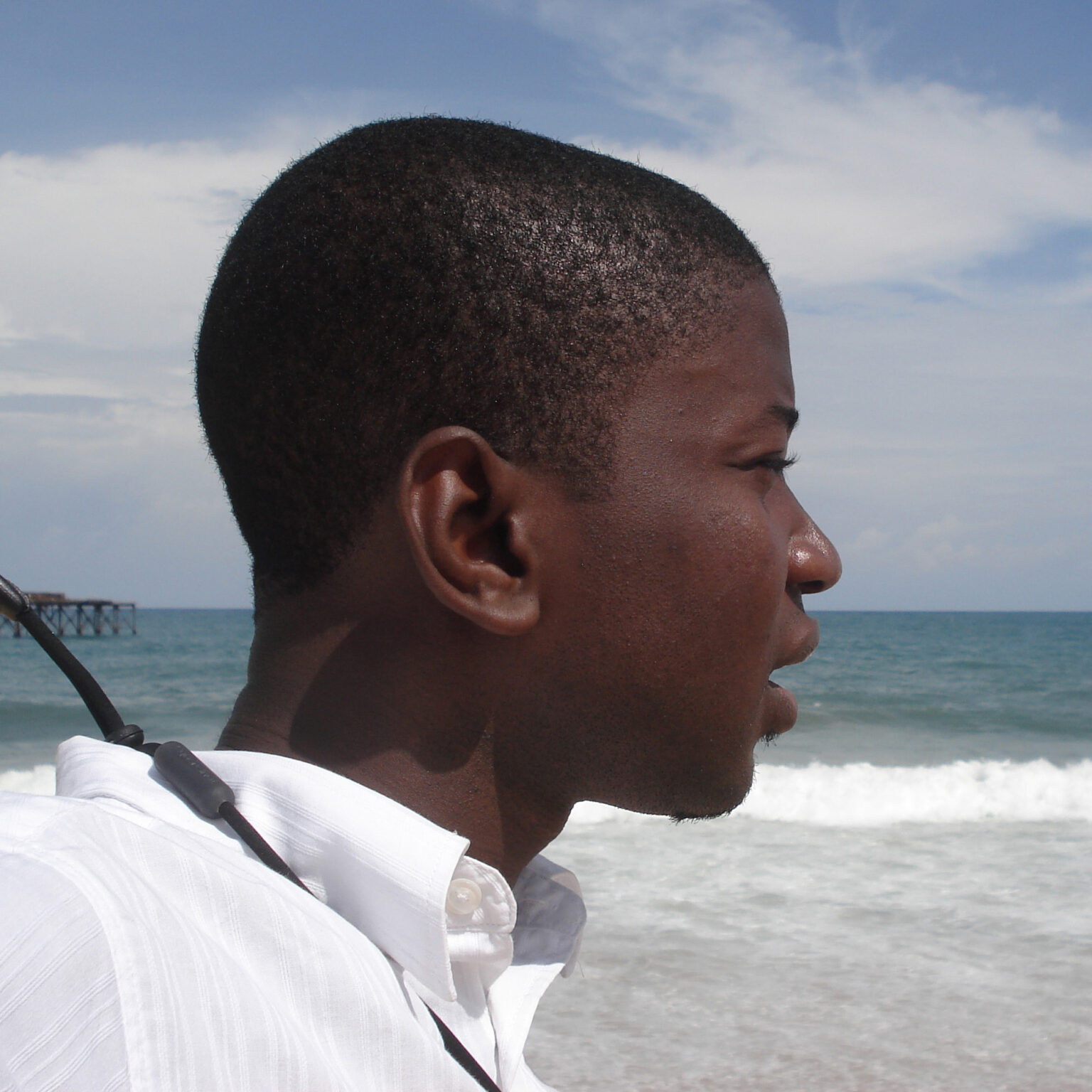 A portrait of a person in front of the ocean.