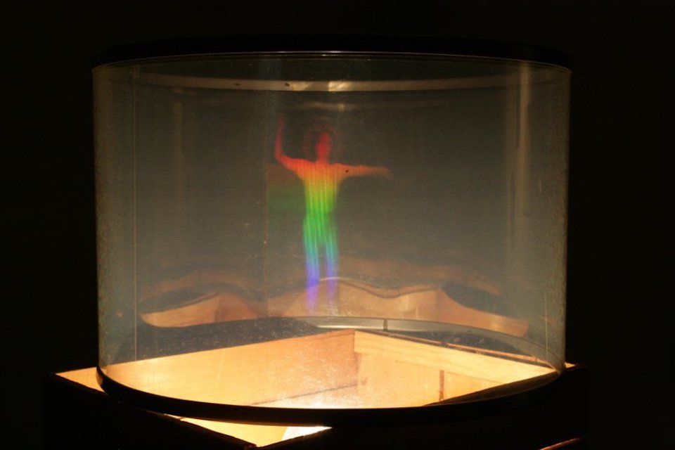 A rainbow colored human figure in a clear tube.