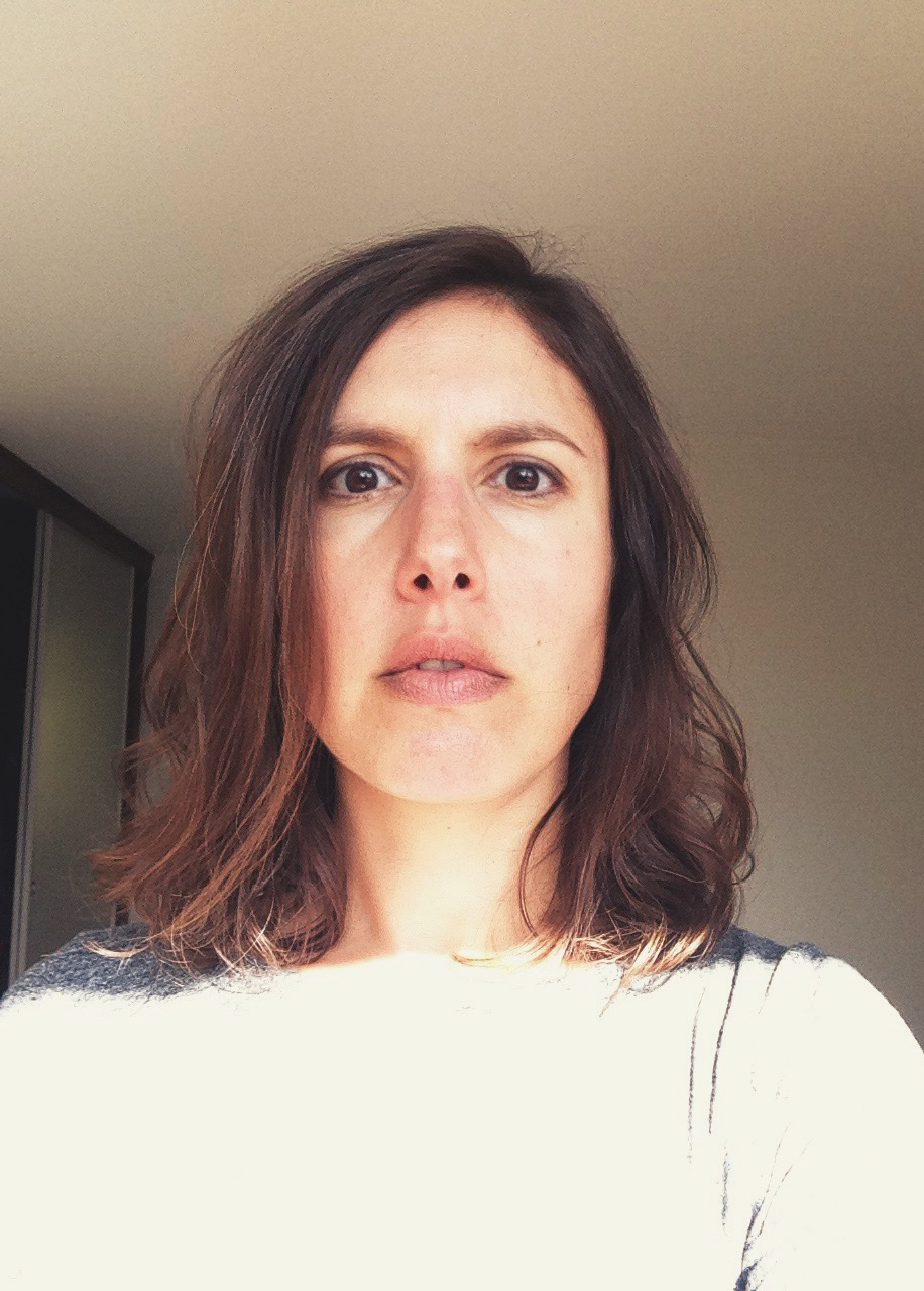 A portrait of a person in front of a light background.