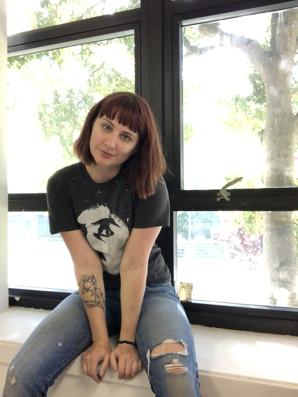 A person sitting in front of a window.