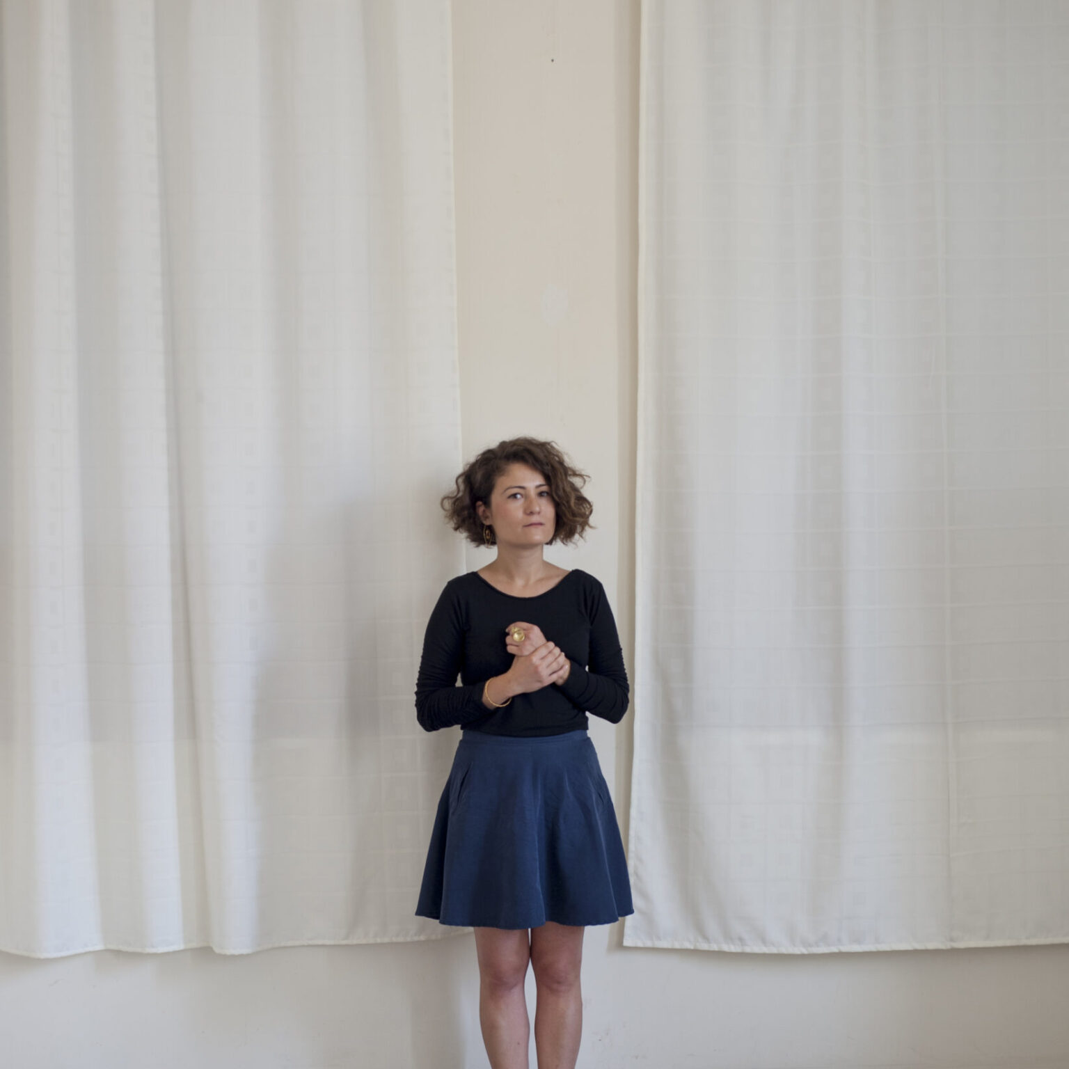 A person standing behind an art installation spread out on the ground.