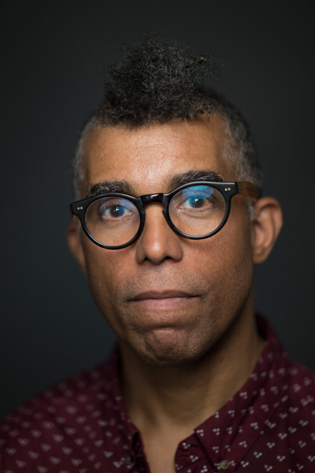 A portrait of a person against a dark background.