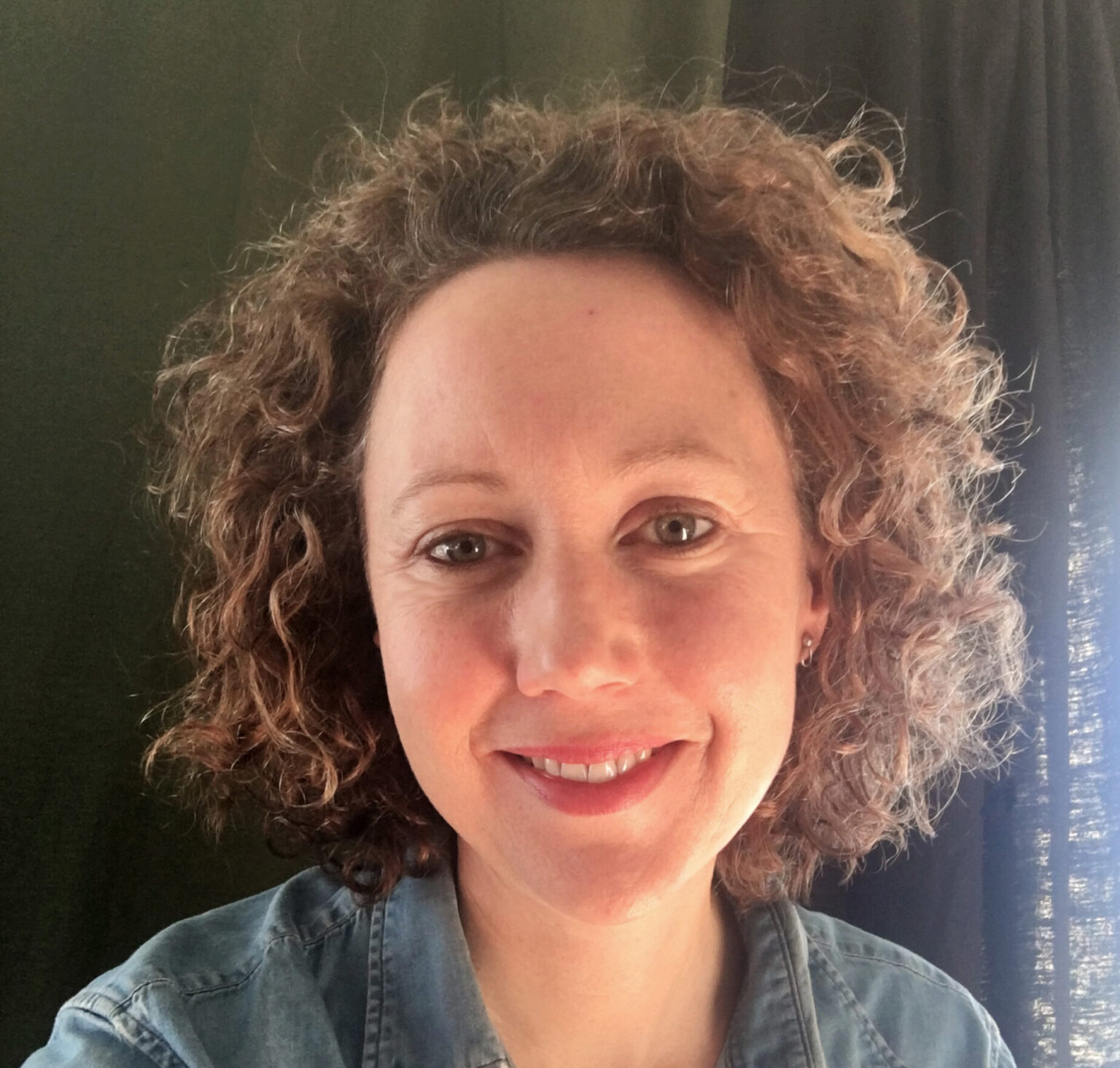 A portrait of a person against a dark background.