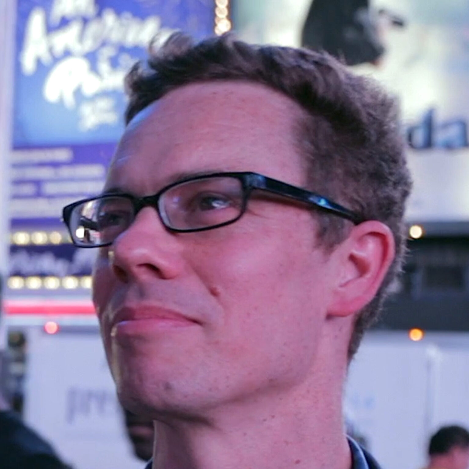 A portrait of a person with an urban setting in the background.