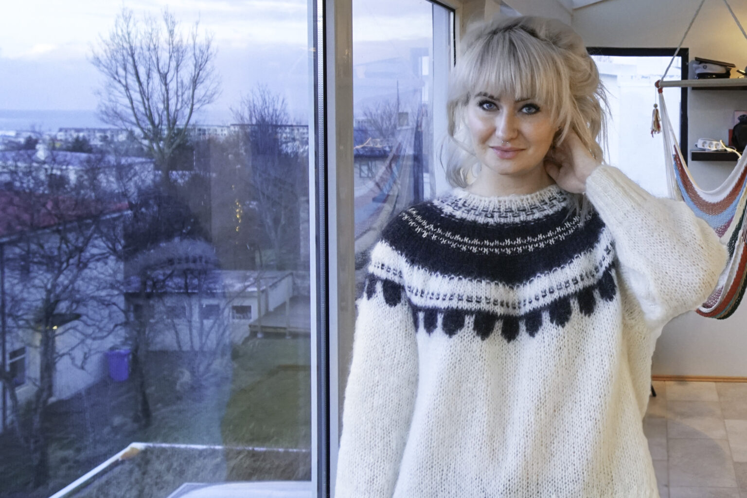 A person standing in front of a window.