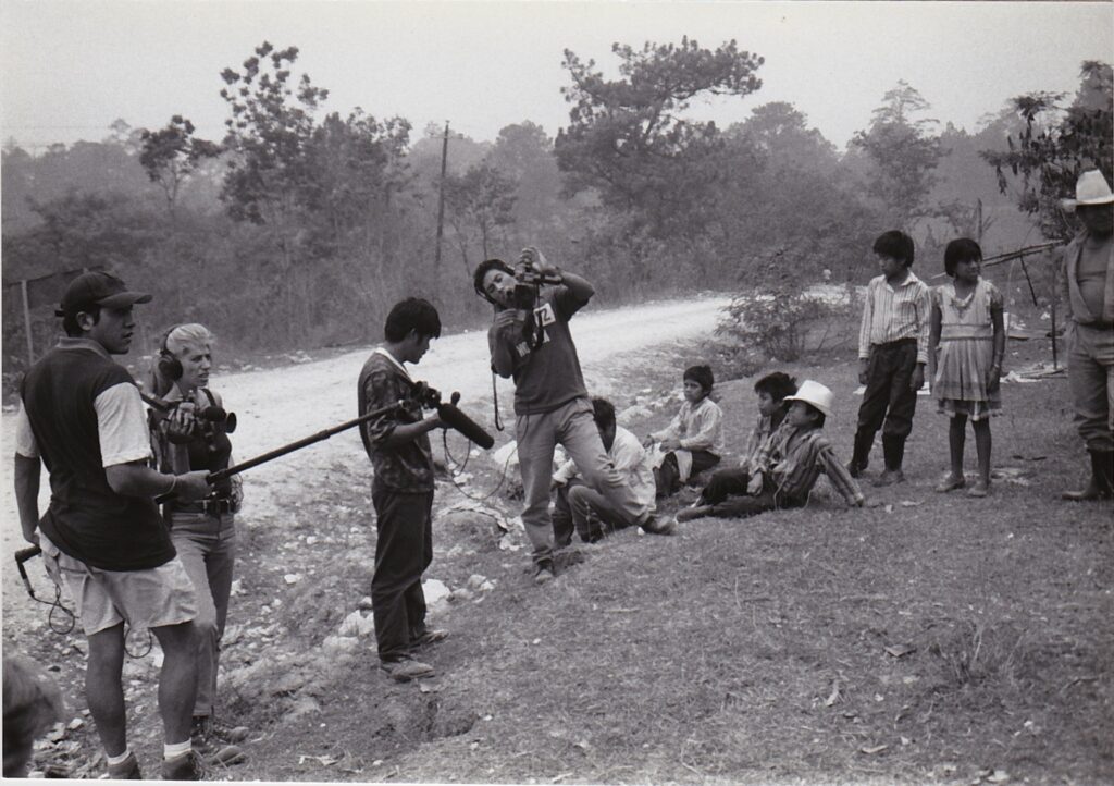 A group of people with recording equipment next to a group of children.