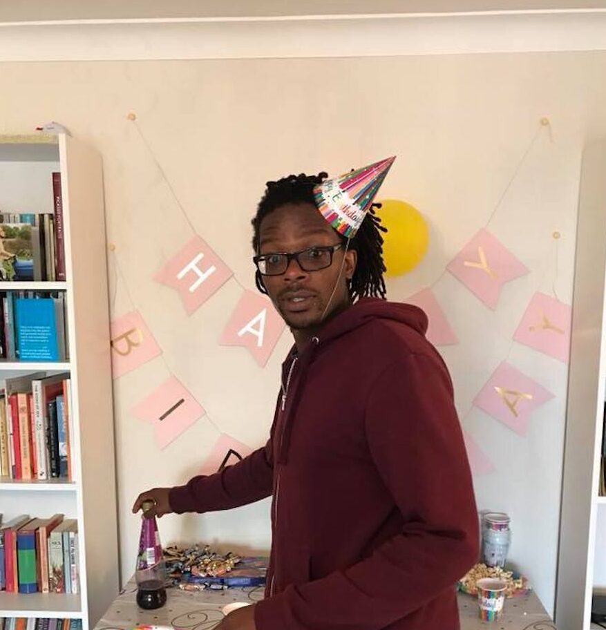 A person standing in front of birthday party decorations.