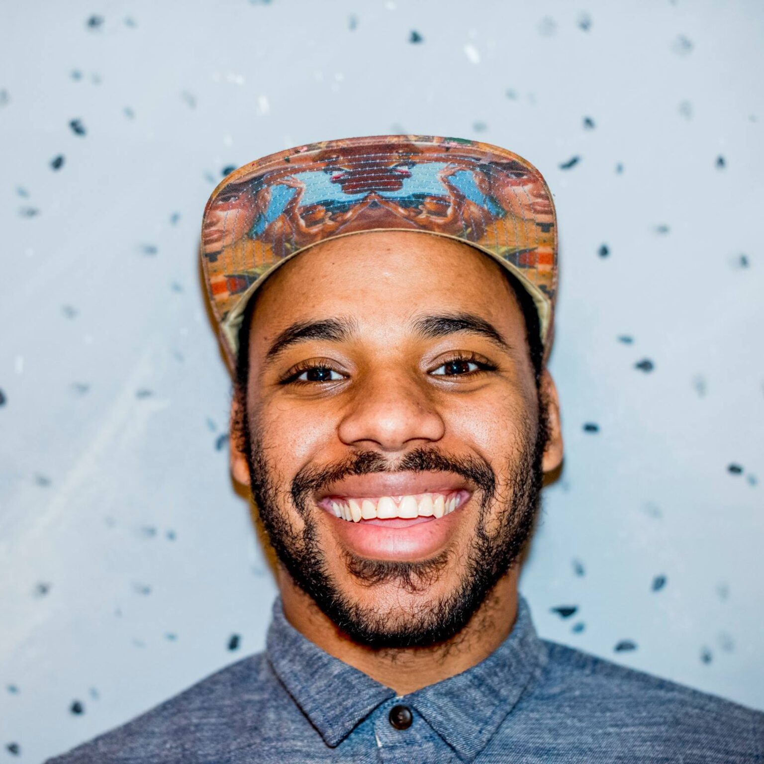 A portrait of a person against a speckled background.