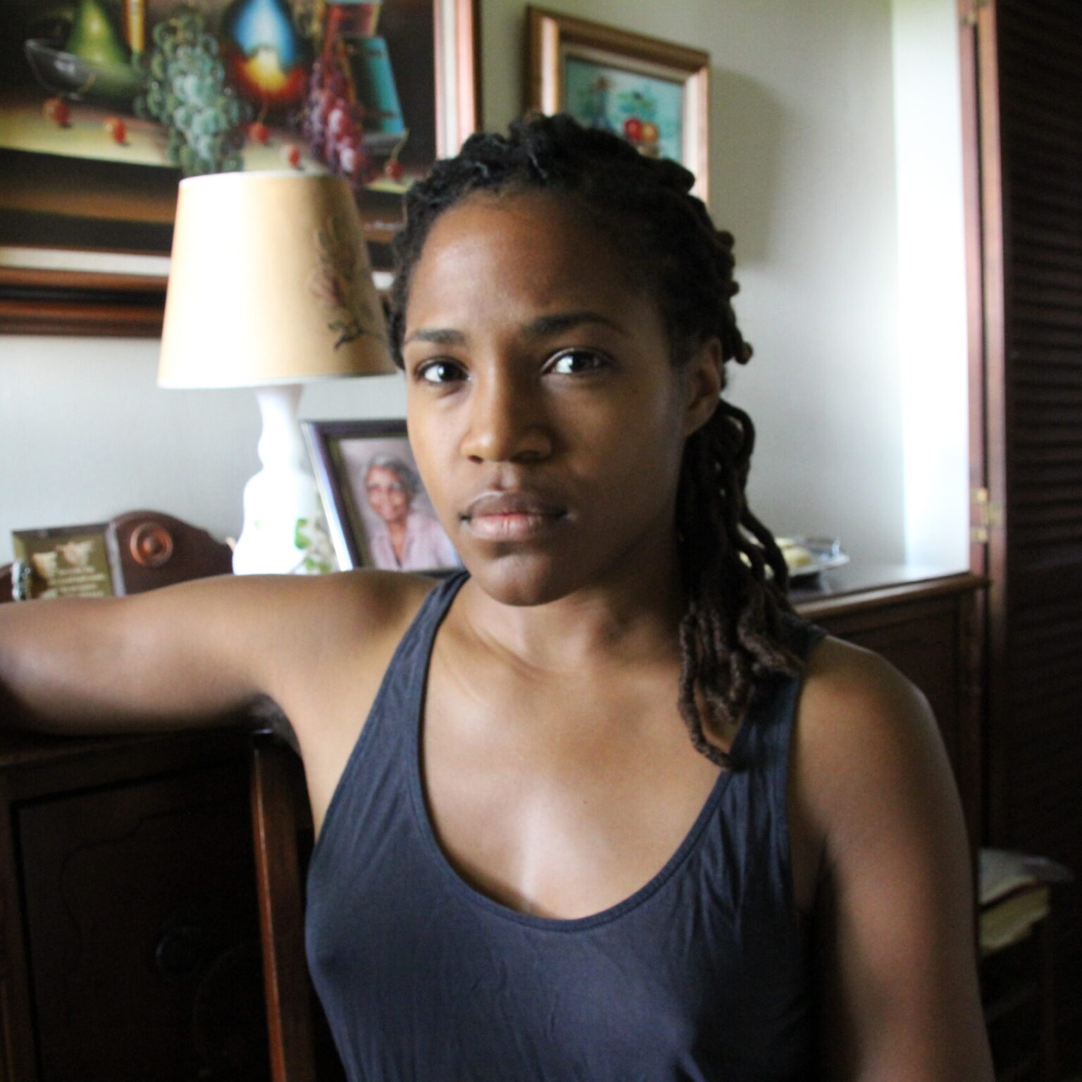A person sitting with a furnished room in the background.