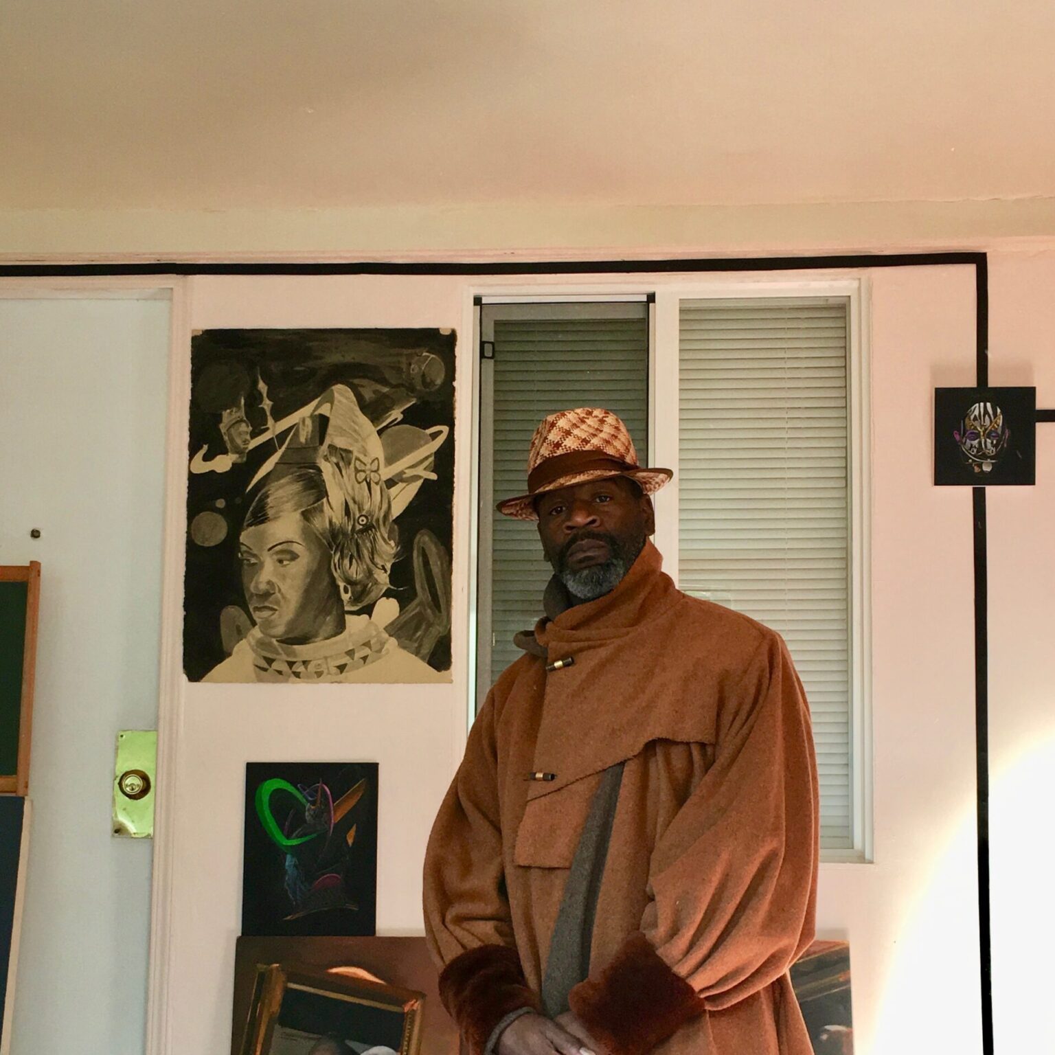 A person standing in front of artworks.