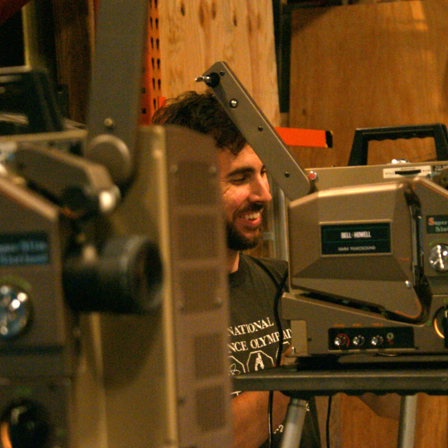 A person sitting among projectors.