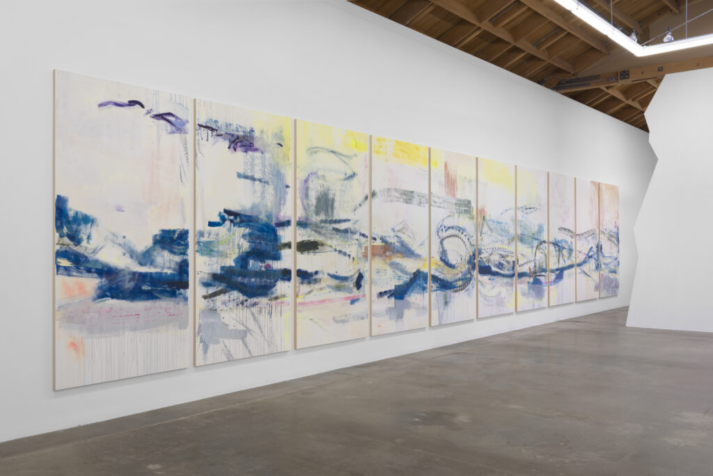 A series of paintings hung in a gallery.