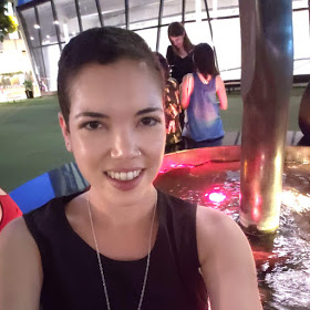 A portrait of a person in front of a decorative fountain.