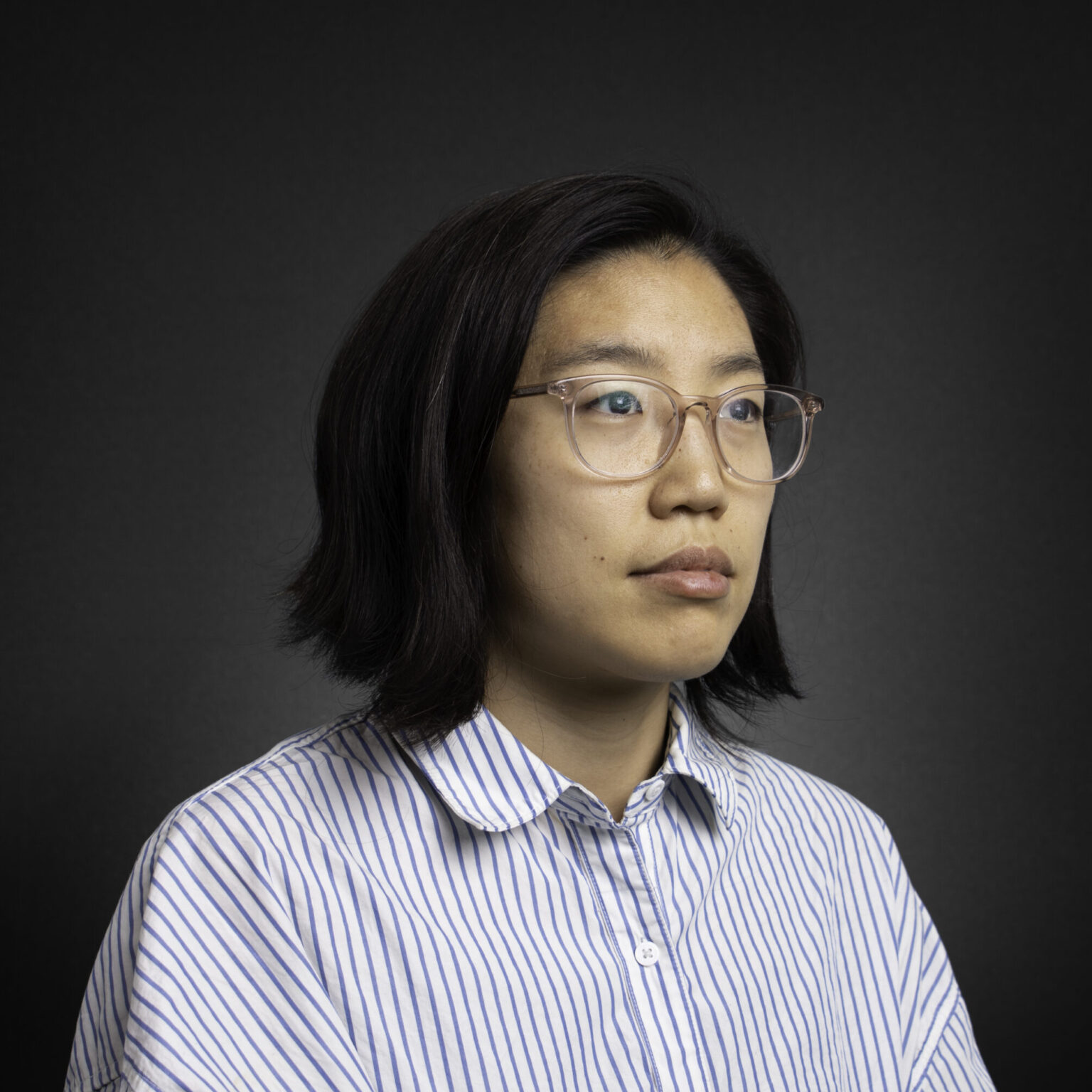 A portrait of a person against a dark background.