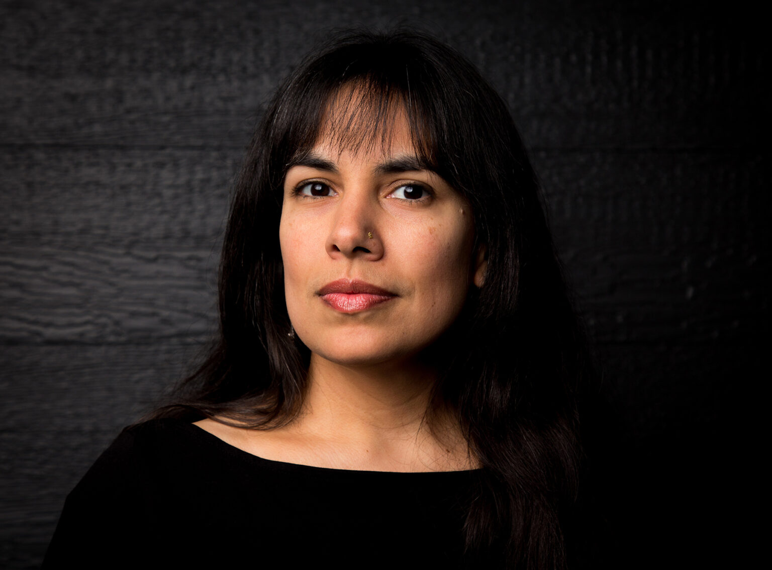 A portrait of a person against a dark background.