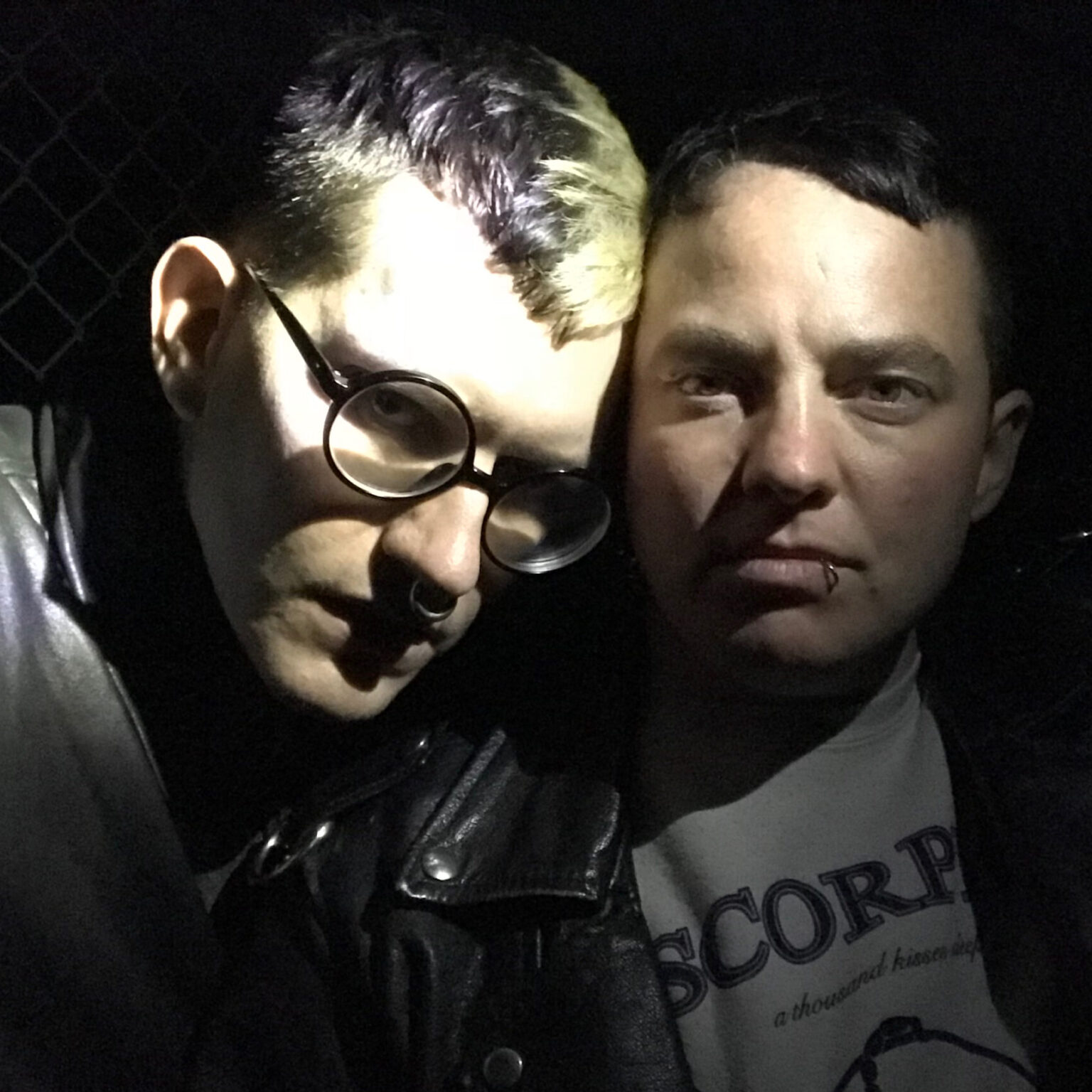 A portrait of two people in partial shadow.