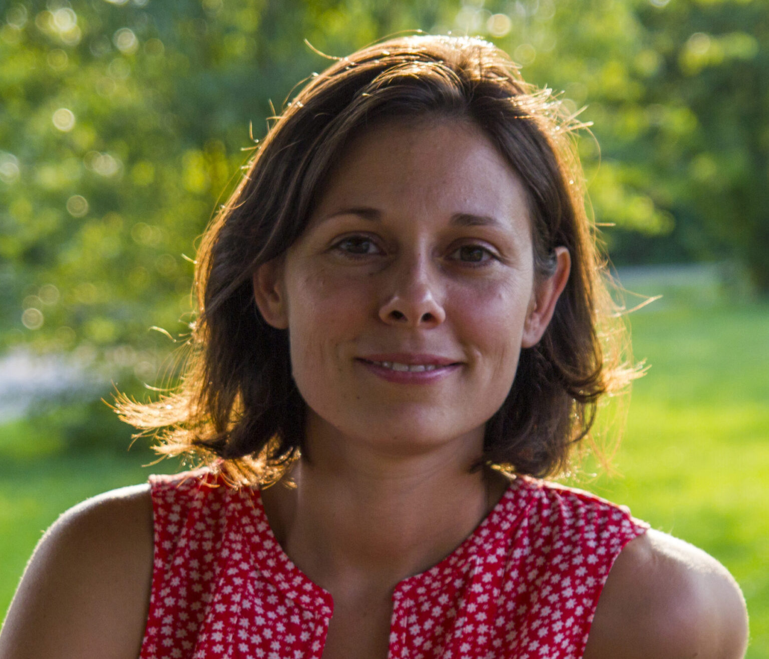 A person in a pink top against grennery