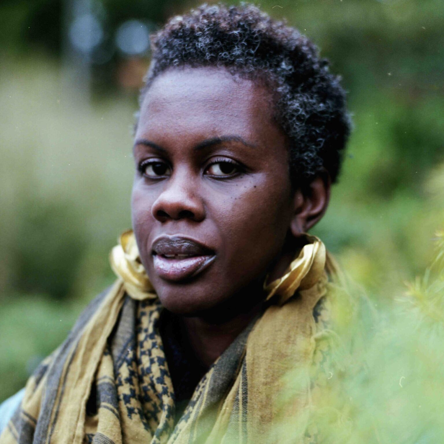 A portrait of a person outside with foliage.