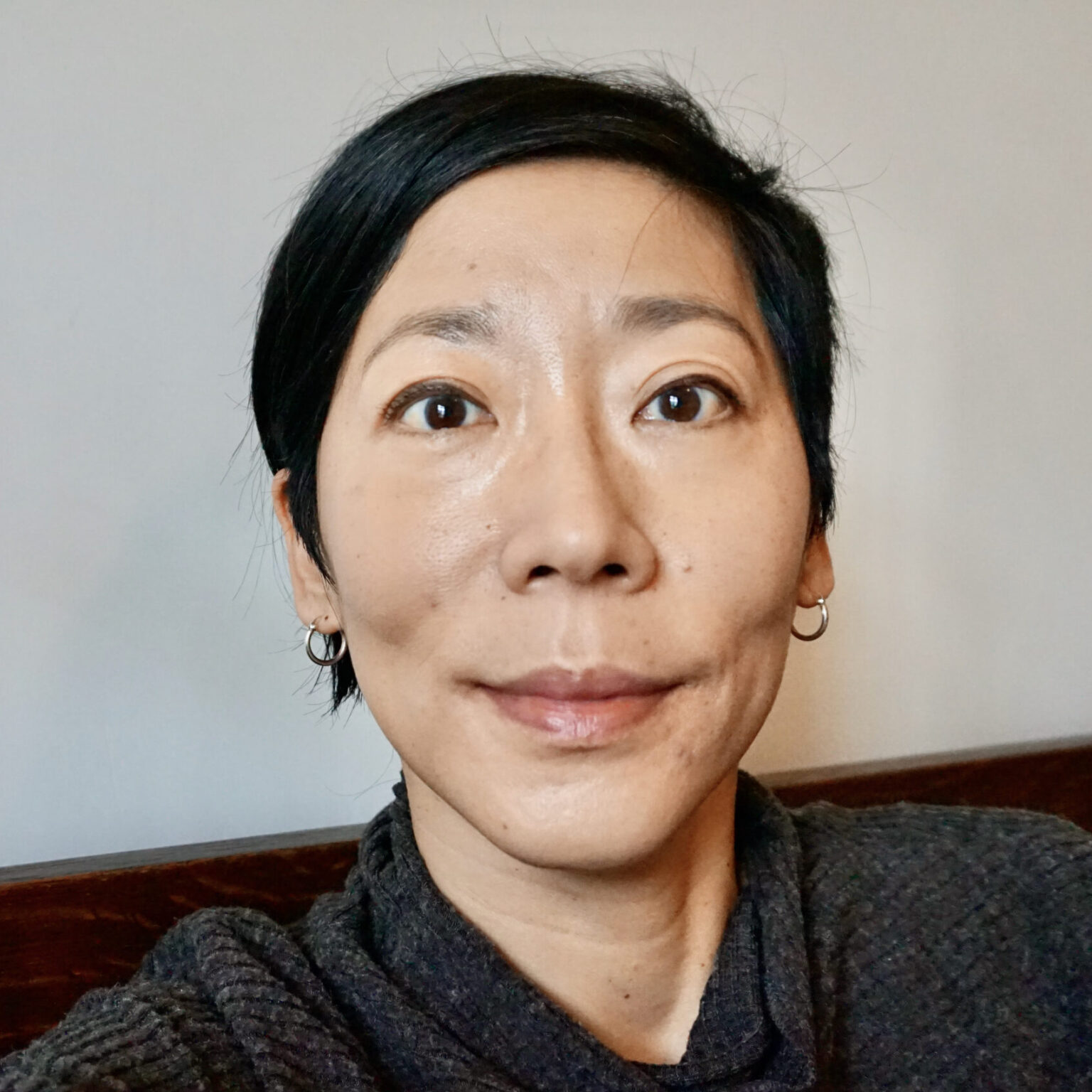 A close-up of a person's face against a white wall.