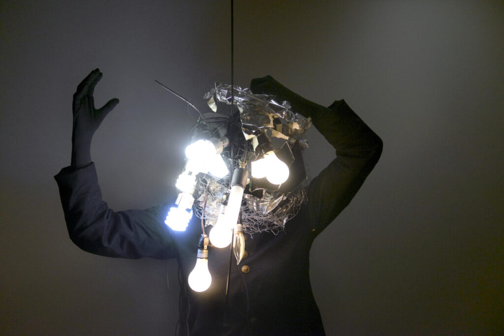 A person holding a large tangled mass of lightbulbs