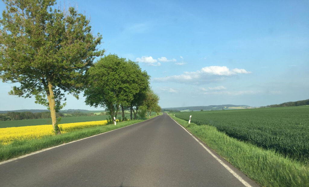 A paved road with green fields on either side.