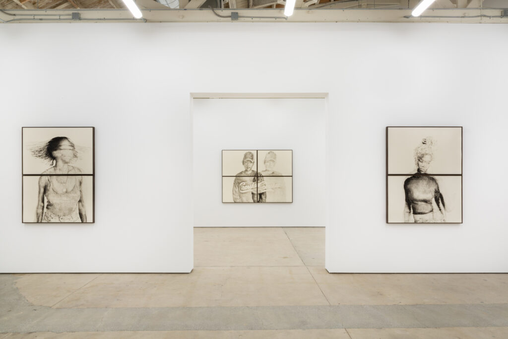 An image of three artworks hung on the white walls of a gallery.