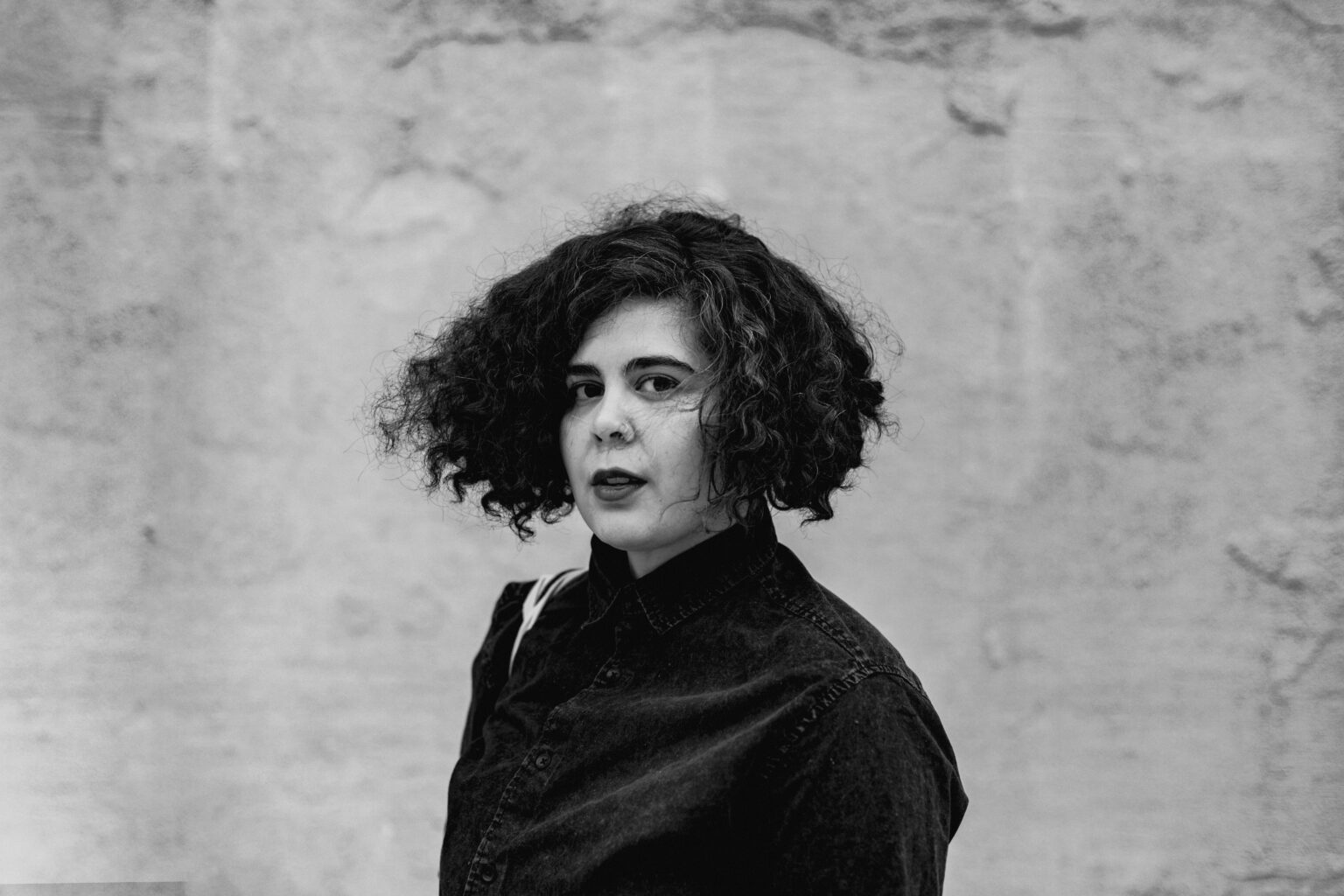 A portrait of a person against a textured background.