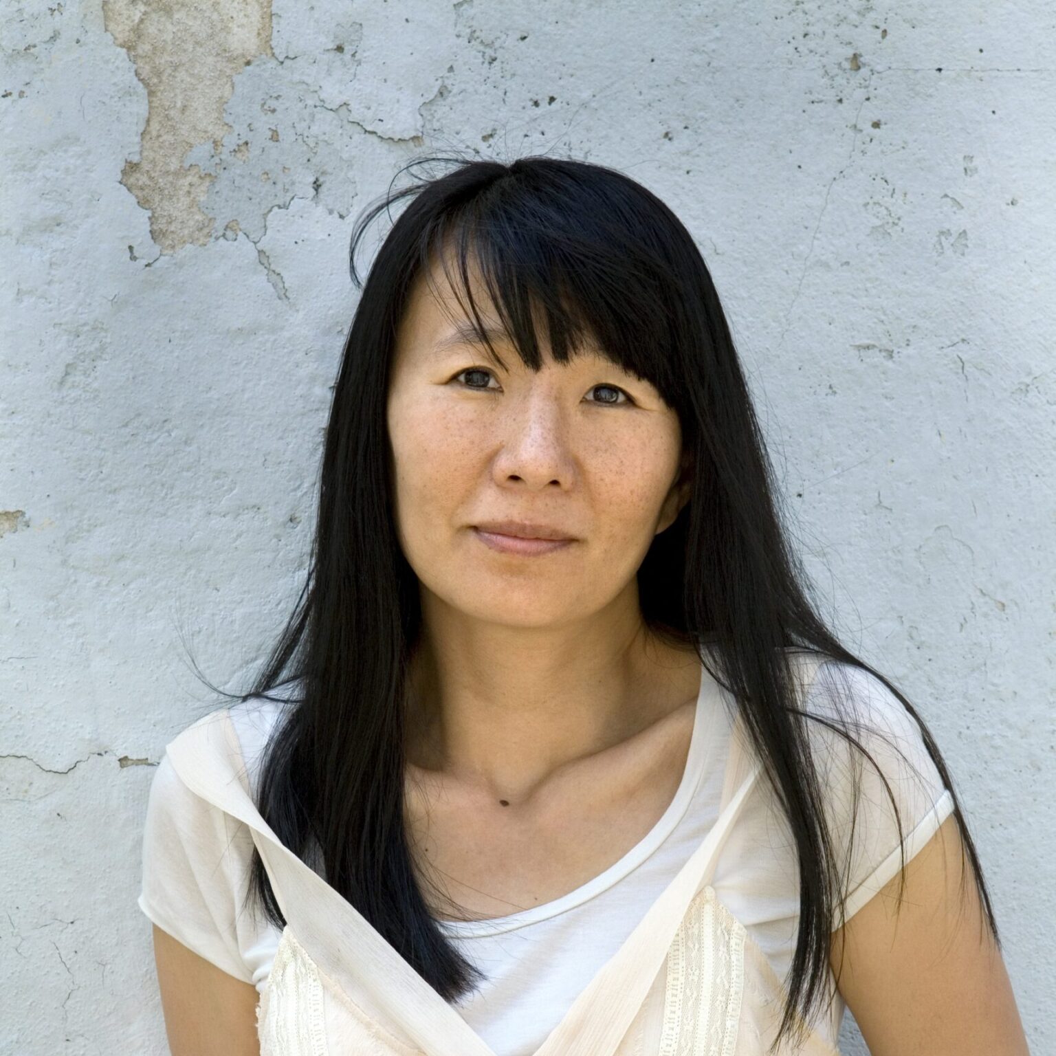 A portrait of a person against a textured background.